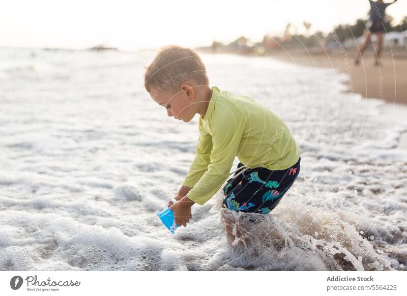 Kind spielt am Sandstrand an einem Sommertag Strand Spielzeug Ufer Wellen sonnig spielen Vorschule Kindheit wenig Küste Natur reisen Strandpromenade Junge