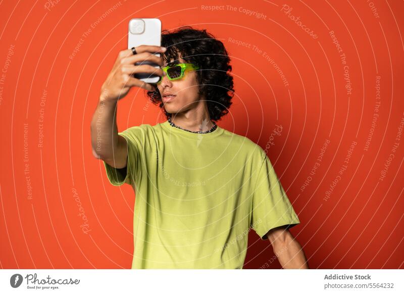 Glücklicher junger ethnischer Mann macht Selfie mit Smartphone Sonnenbrille Lächeln benutzend positiv heiter männlich stehen Lateinamerikaner hispanisch Mobile