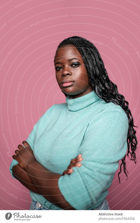 Selbstbewusste afrikanische Frau vor rosa Hintergrund Afrikanisch Selbstvertrauen Minze grün Rollkragenpulli Pullover Zopf Behaarung Pose Schönheit Mode Porträt