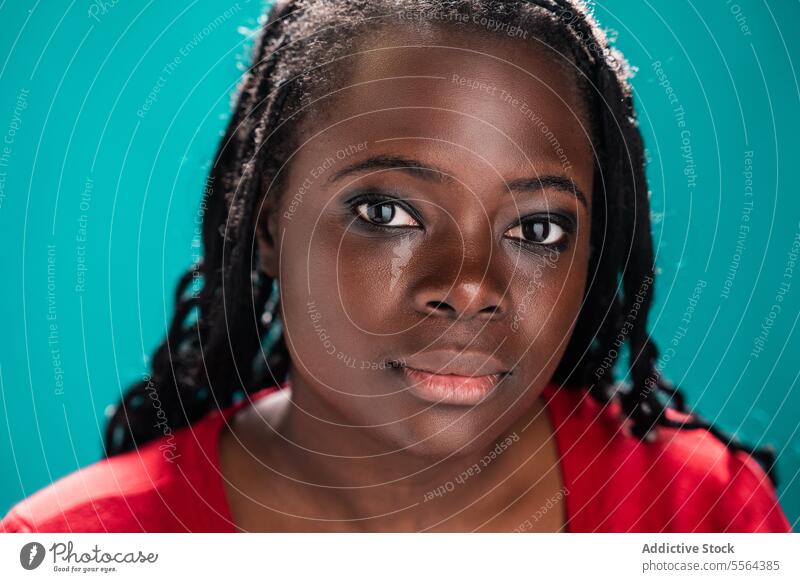 Detaillierter Blick auf eine afrikanische Frau vor einem blaugrünen Hintergrund Nahaufnahme Afrikanisch Auge Make-up türkis Schönheit Ausdruck Detailaufnahme