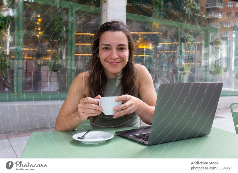 Junger Freiberufler trinkt heißen Kaffee in einem Café Frau freiberuflich trinken abgelegen Arbeit Lächeln Glück Laptop Apparatur jung Tisch Heißgetränk