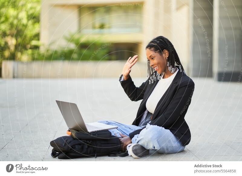 Lächelnde afroamerikanische Geschäftsfrau, die über einen Laptop spricht Frau pc Straße benutzend Smartphone Gerät reden Video-Chat Kommunizieren sprechen