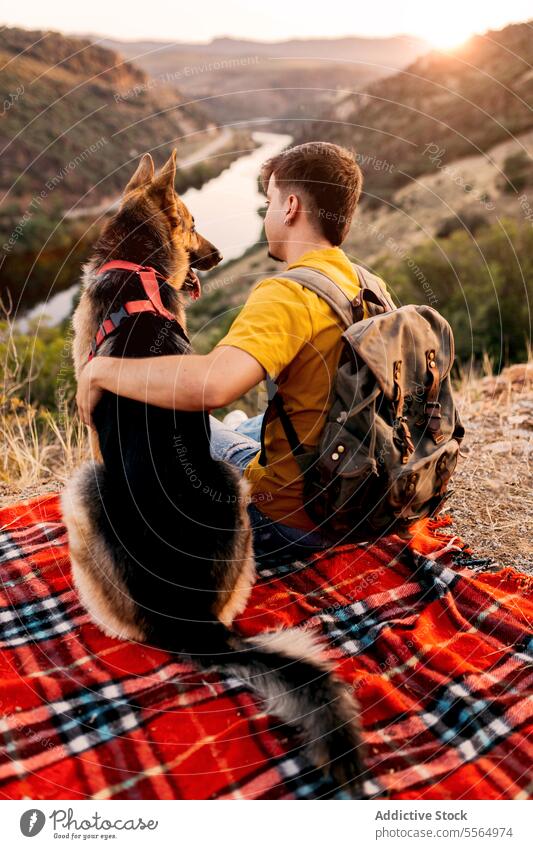 Unbekannter Reisender sitzt mit Hund auf einem Hügel Mann reisen Tourist Haustier Berge u. Gebirge bewundern Hochland malerisch Natur Border Collie