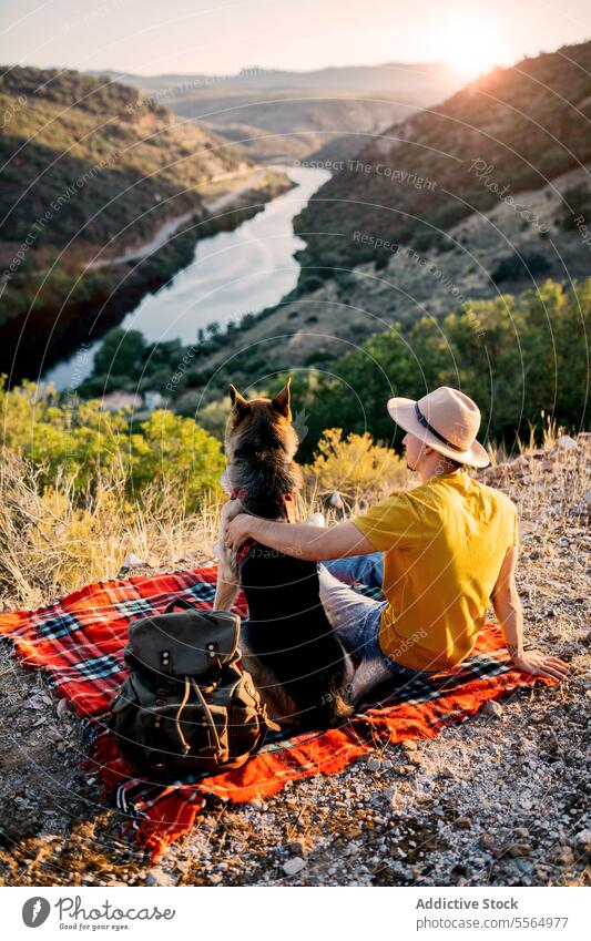 Unbekannter Reisender sitzt mit Hund auf einem Hügel Mann reisen Tourist Haustier Berge u. Gebirge bewundern Hochland malerisch Natur Border Collie Tier