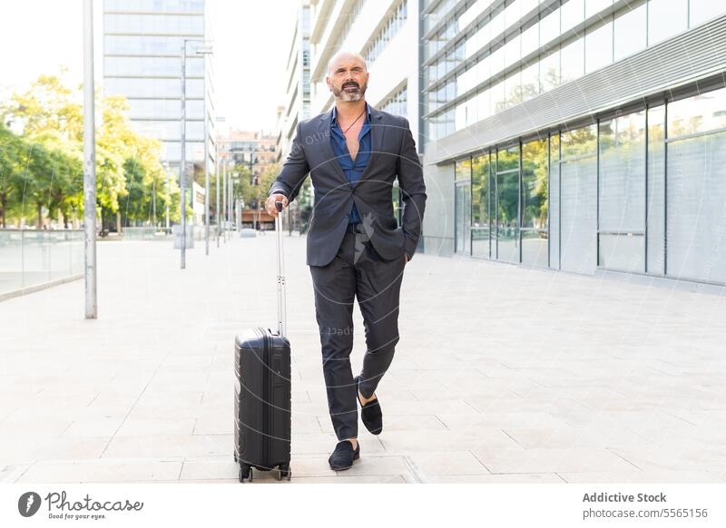 Geschäftsmann geht mit seinem Koffer die Straße entlang Mann Business Person Erwachsener laufen Gepäck Geschäftsreisen Stadtstraße Lifestyle im Freien Tag