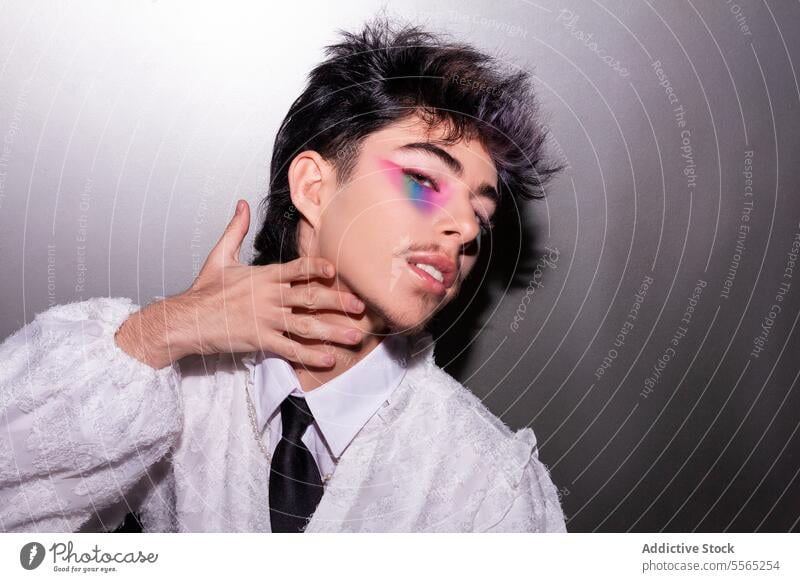 Mann im Profil mit lebhaftem Regenbogen-Makeup Make-up Auge Behaarung strubbelig Hand Hals Hintergrund neutral Seite Mode Stil Zeitgenosse Gesicht Nahaufnahme