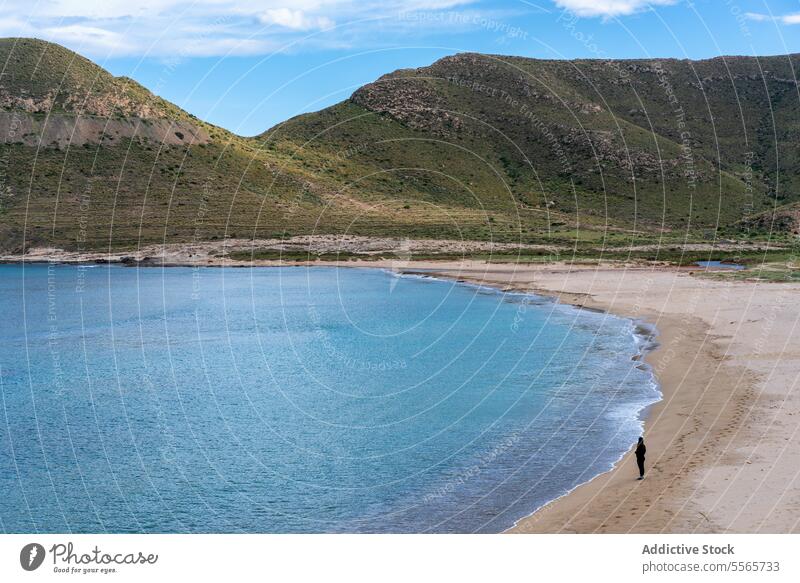 Frau am Ufer eines Strandes in der Nähe von Bergen MEER Natur mediterran Meereslandschaft Küstenlinie reisen Sand Urlaub im Freien Felsen Wasser Tourismus