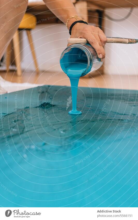 Crop Artist malt auf dem Boden im Zimmer Farbe eingießen Künstler Anstreicher Pinselblume Kunst Acryl liquide Kunstwerk blau Handwerk Fähigkeit Prozess kreativ