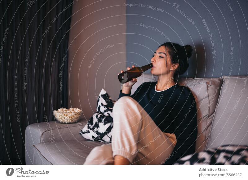Junge Frau ruht sich auf dem Sofa aus und trinkt Bier trinken sich[Akk] entspannen Komfort Flasche gemütlich Wohnzimmer zu Hause jung Kälte Wochenende Liege