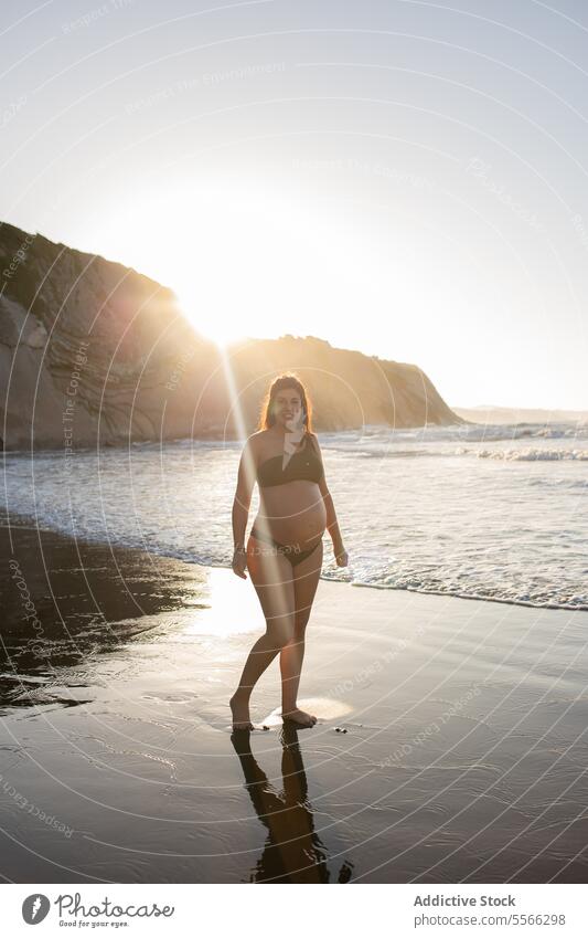 Schwangere Frau geht am Meer spazieren Spaziergang MEER Schwangerschaft Küste Ufer schwanger Angebot Mutter Eltern erwarten Barfuß vorwegnehmen mütterlich