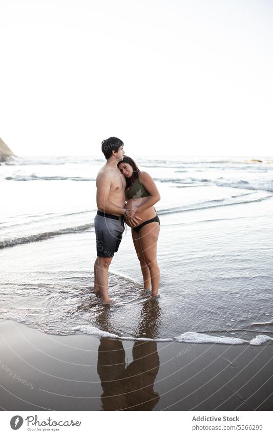 Mann berührt den Bauch einer schwangeren Frau am Meeresufer Paar MEER Sonnenuntergang berühren Zusammensein Liebe Schwangerschaft Abend Angebot Sommer