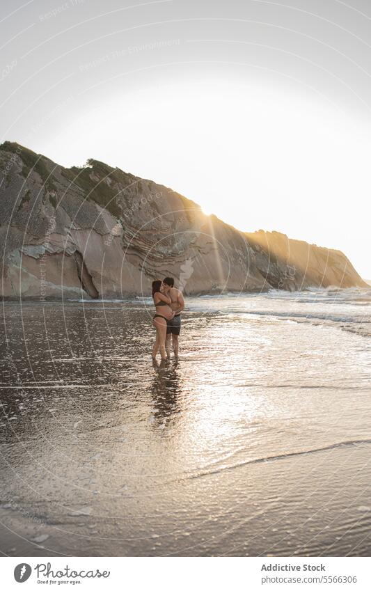 Schwangere Paar küssen im Meer am Abend Kuss MEER Küste schwanger Umarmung Liebe Partnerschaft Mann Frau Umarmen erwarten vorwegnehmen Ufer Zusammensein Urlaub