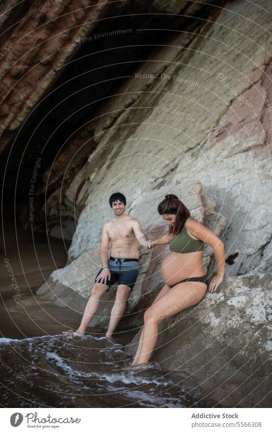 Mann und schwangere Frau ruhen sich auf einem rauen Berg am Meer aus MEER Ufer Stein fettarm Wasser Sommer Natur Küste sich[Akk] entspannen Schwangerschaft