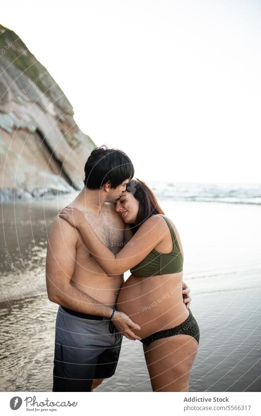 Mann küsst und berührt den Bauch einer schwangeren Frau am Meeresstrand Paar MEER Sonnenuntergang berühren Zusammensein Liebe Schwangerschaft Abend Angebot