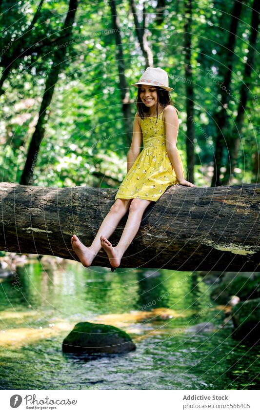 Fröhliches Mädchen im Teenageralter sitzt auf einem Baumstamm in der Natur Wald Kofferraum sich[Akk] entspannen Entdecker Pause Erholung Abenteuer ruhig