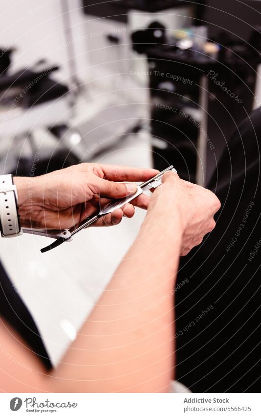Hände eines Friseurs mit Rasiermesser in einem Friseursalon. Hand Rasierer Klinge Salon Nahaufnahme Halt Präzision Werkzeug Haarschnitt vorbereiten Kompetenz