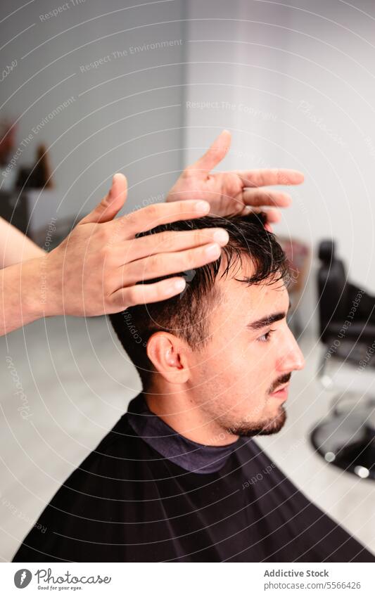 Nahaufnahme von Friseurhänden, die das Haar eines Kunden im Salon richten Hände stylen Einstellung Klient Mann Behaarung männlich Fokus Detailaufnahme Pflege
