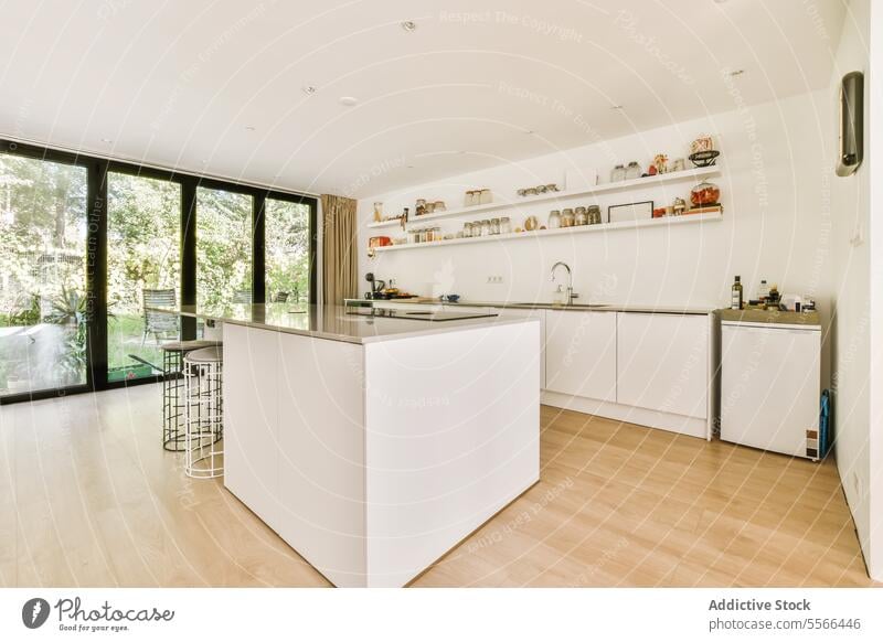 Moderne Küche mit weißer Arbeitsplatte und großem Fenster Insel Regal notwendig geräumig Innenbereich Essen zubereiten modern heimwärts Einführung Vorratskammer