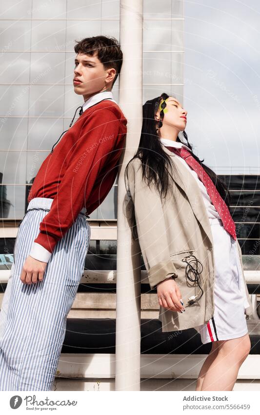 Junge Frau und junger Mann posieren in städtischer Umgebung mit Mode-Stil. Gen-Z urban Arbeit Großstadt Pose Selbstvertrauen trendy Hintergrund männlich Make-up