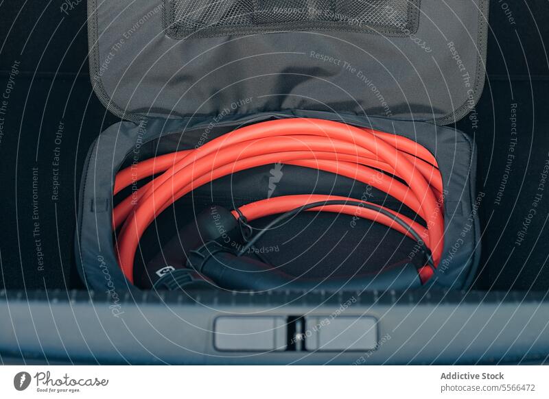 Ladekabel für Elektrofahrzeuge im Kofferraum elektrisch Fahrzeug Aufladen Kabel orange Lager Tasche grau aufgerollt PKW Gerät EV Verkehr Stecker Zwischenstück