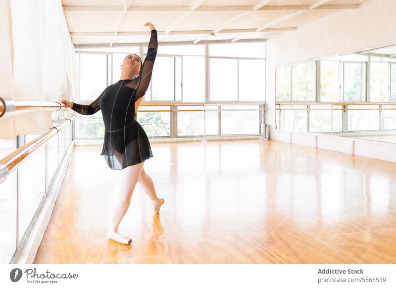Tänzerin balanciert im hellen Studio Balletttänzer Atelier Stange Licht Fenster Anmut Fokus Arme anbauen spitze Schuh Gleichgewicht Frau Eleganz Formular Pose