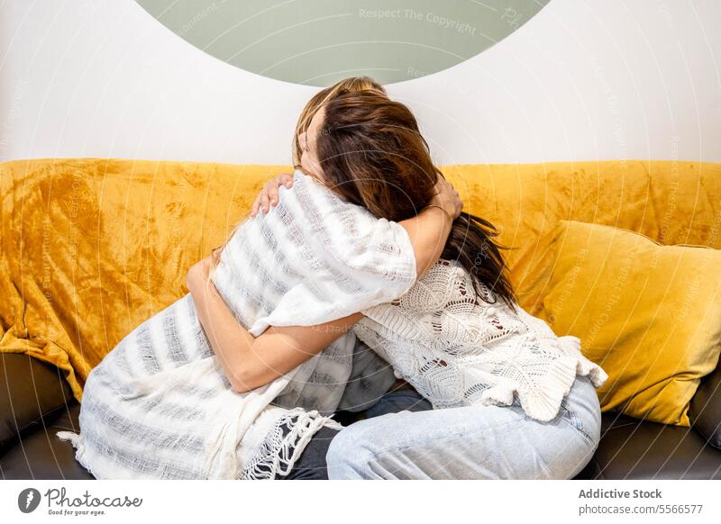 Zwei Frauen, die auf einem Sofa sitzen und sich umarmen Umarmung Sitzen Liege bedeckt Decke psychologisch Therapie emotional Erholung Komfort gemütlich