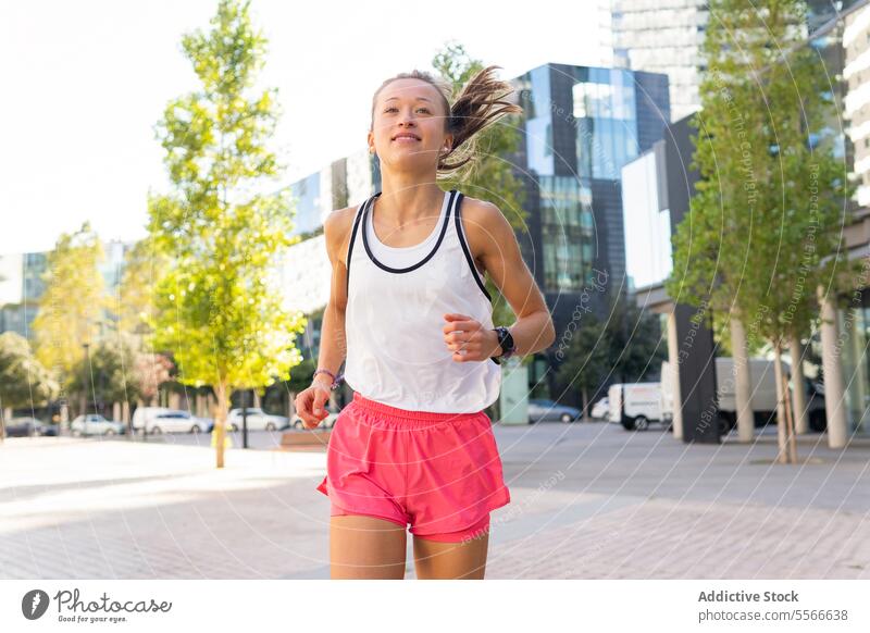 Eine Frau, die auf einem Bürgersteig in einer Stadt läuft laufen Großstadt urban Fitness Sport aktiv Metropolitan Lifestyle Dschungel Übung Straßenbelag joggen