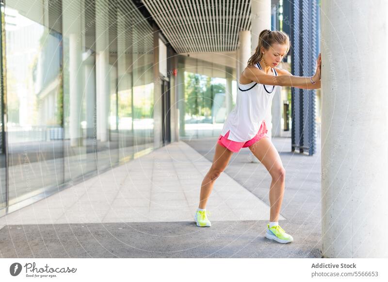 Eine Frau in einem weißen Tanktop und rosa Shorts, die sich streckt Fitness aktiv Übung Training strecken Sport Gesundheit Wellness Athlet passen Flexibilität