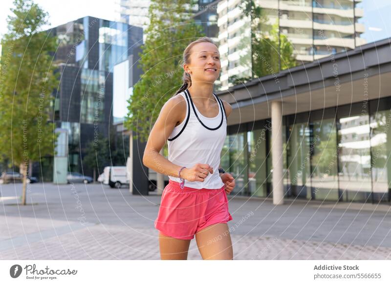 Eine Frau, die auf einem Bürgersteig in einer Stadt läuft laufen Großstadt urban Fitness Sport aktiv Metropolitan Lifestyle Dschungel Übung Straßenbelag joggen