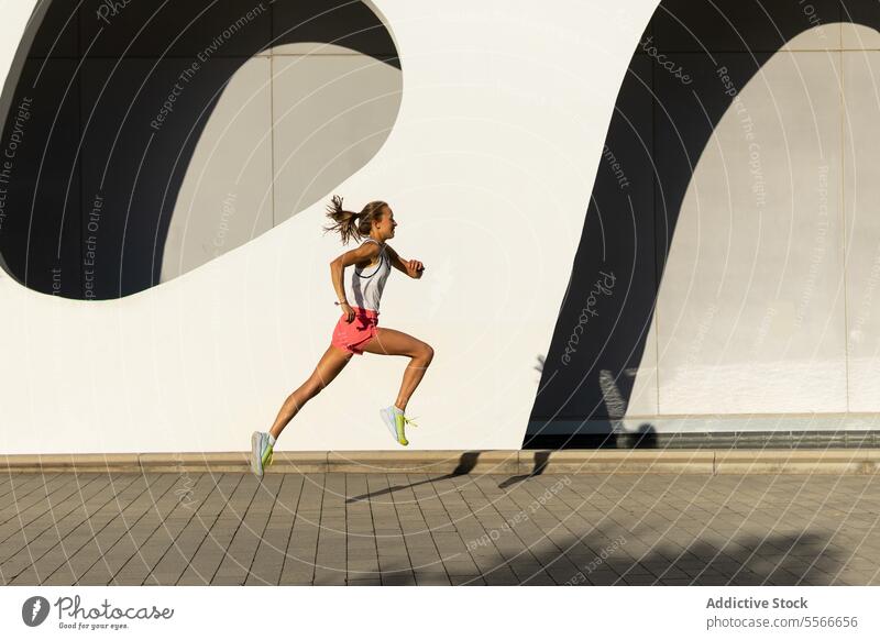 Eine Frau läuft auf einer Ziegelsteinstraße rennen Baustein Straße Großstadt Fitness Übung joggen Training Athlet aktiv Straßenbelag urban im Freien Gesundheit
