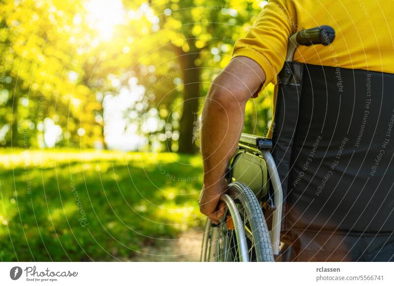 Close up von älteren behinderten Mann im Rollstuhl sitzen während des Spaziergangs im Park mit copyspace, reifen behinderten alten Mann Großvater in Invalidenwagen oder Rollstuhl, ältere Menschen Behinderung Konzept Bild