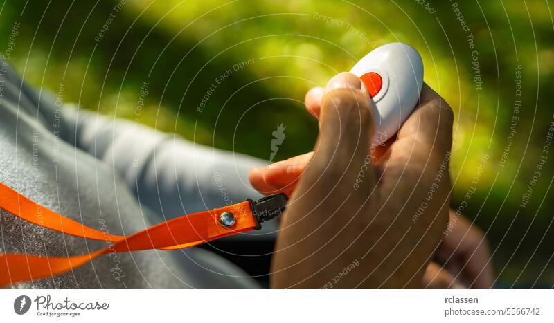 Älterer Mann drückt Alarmknopf für Notruf in einem Park im Freien. Hand medizinisch Alarmanlage Alarmtaste Senior älter Panik Hilfsbereitschaft Pflege abstützen