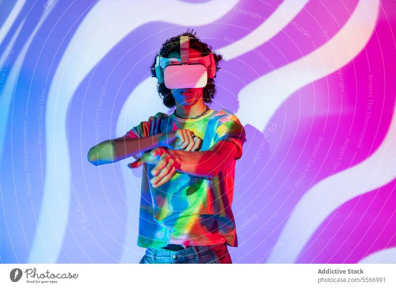 Lateinamerikanischer Mann in Krawattenfarbe erkundet virtuelle Realität mit Headset Brille tie-dye Hemd VR interagieren blau purpur Hintergrund Verwirbelung