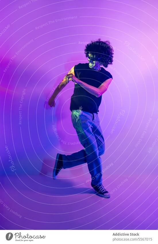 Energetische Tanz der lateinischen Mann in Neon-Licht lila Hintergrund Tanzen neonfarbig Fliederbusch krause Haare dynamisch Latein Bewegung Energie purpur