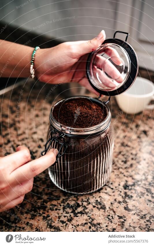 Öffnen des Kaffeeglases Hand Glas Boden Textur Granit Arbeitsplatte Deckel Metall aromatisch Vorbereitung heimwärts brauen Italienisch Nahaufnahme Bohne Lager