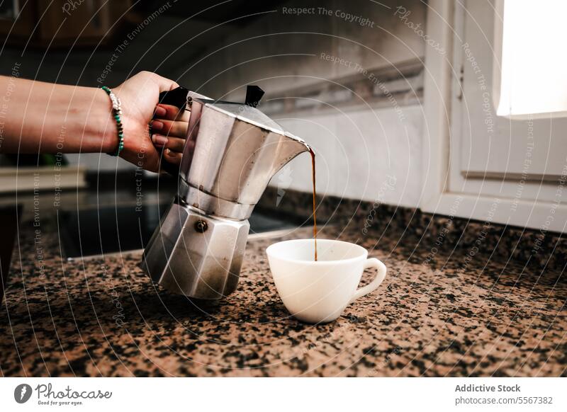Ritual des morgendlichen Einschenkens Hand Armband türkis Kaffee eingießen Espresso Herstellerin Herdplatte Tasse Küche modern brauen Abfertigungsschalter
