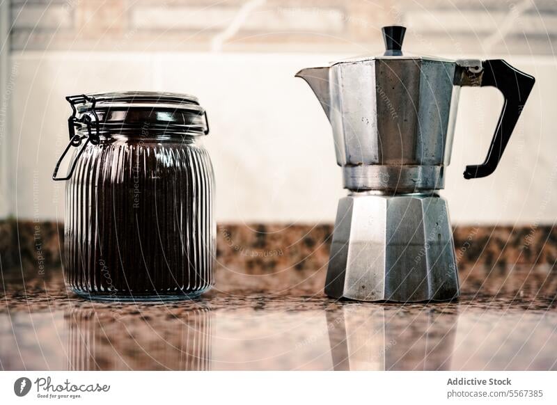 Glasgefäß und Mokkakanne auf Granit Topf Kaffee Arbeitsplatte Küche einklemmen Deckel Metall Reflexion & Spiegelung Italienisch brauen altehrwürdig Silber