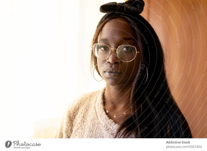 Nachdenkliche afroamerikanische Dame zu Hause Afroamerikaner Porträt Brille Stirnband schwarz texturiert Pullover Licht Ruhe Gedanke fokussiert Gelassenheit