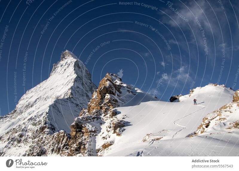 Person mit Skiausrüstung beim Besteigen eines schneebedeckten Berges Rückansicht unkenntlich Mast laufen Schnee deckend Klettern Berge u. Gebirge Urlaub Gerät