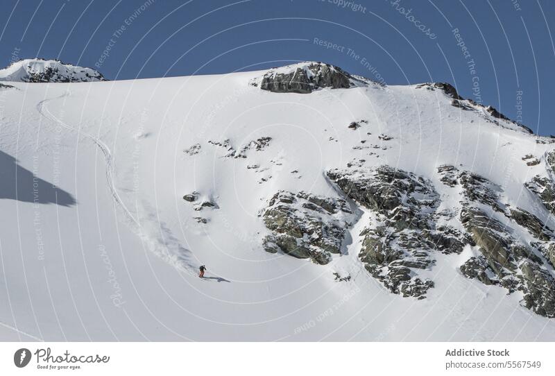 Person beim Skifahren auf einem schneebedeckten Berg im Urlaub unkenntlich Berge u. Gebirge Gerät Skifahrer verschneite wandern Natur Ganzkörper sonnig Winter