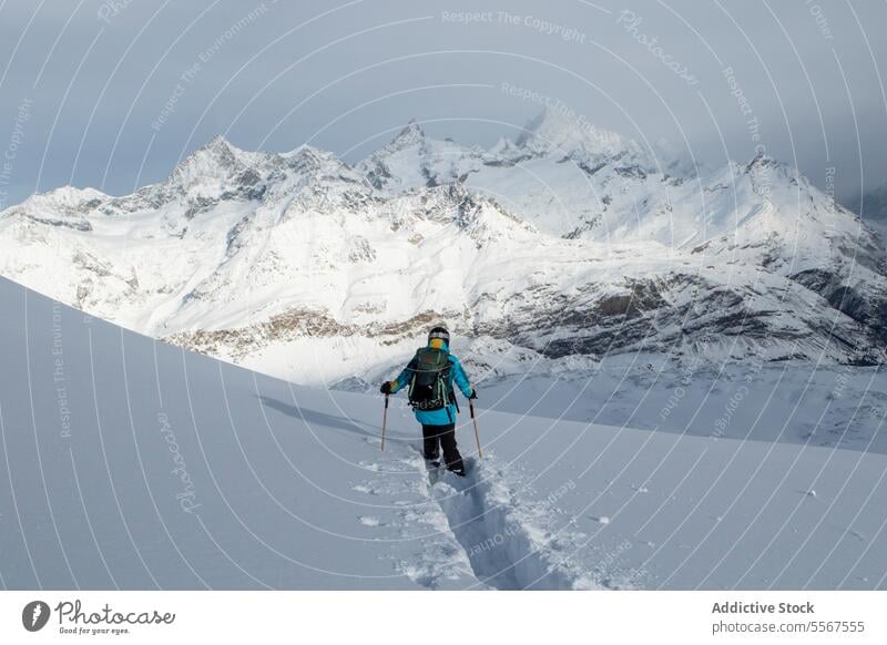 Anonyme Person beim Abstieg von einem schneebedeckten Berg Skifahrer Schnee absteigend Berge u. Gebirge unkenntlich Mast Rückansicht deckend Skifahren