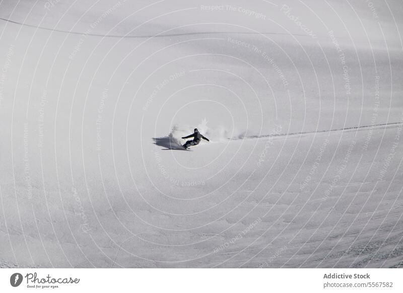 Person beim Snowboarden in einer verschneiten Landschaft im Urlaub Snowboarding unkenntlich Ski Natur Berge u. Gebirge Gerät Snowboarder Ganzkörper sonnig