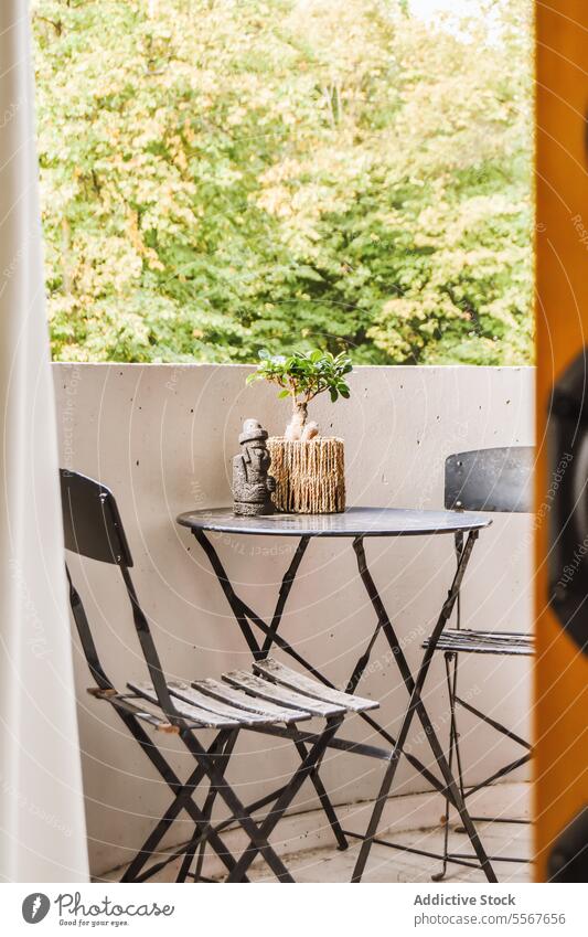 Balkon mit Dekoren auf schwarzem Tisch mit Stühlen Stuhl Pflanze Figur klein Wohnkultur Möbel Haus modern Baum grün Zimmerpflanze Dekoration & Verzierung