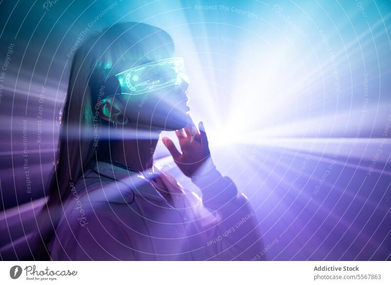 Frau in VR-Brille berührt Gesicht mit Lichtern futuristisch erkunden Cyberspace Studioaufnahme sich[Dat] einbilden lange Haare Pony trendy Stil blond Headset