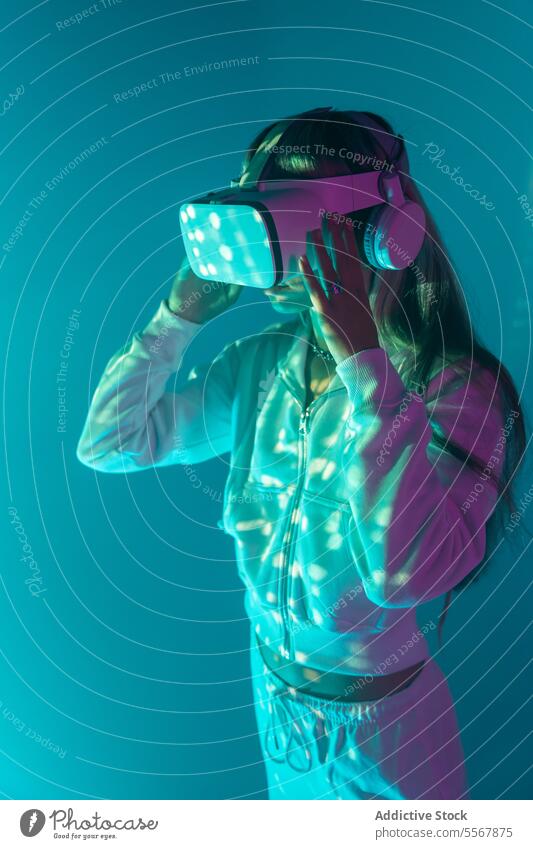 Anonyme Frau mit VR-Brille erkundet den Cyberspace auf glühenden Lichtern Schutzbrille erkunden Virtuelle Realität jung Headset Simulator erweitert Innovation