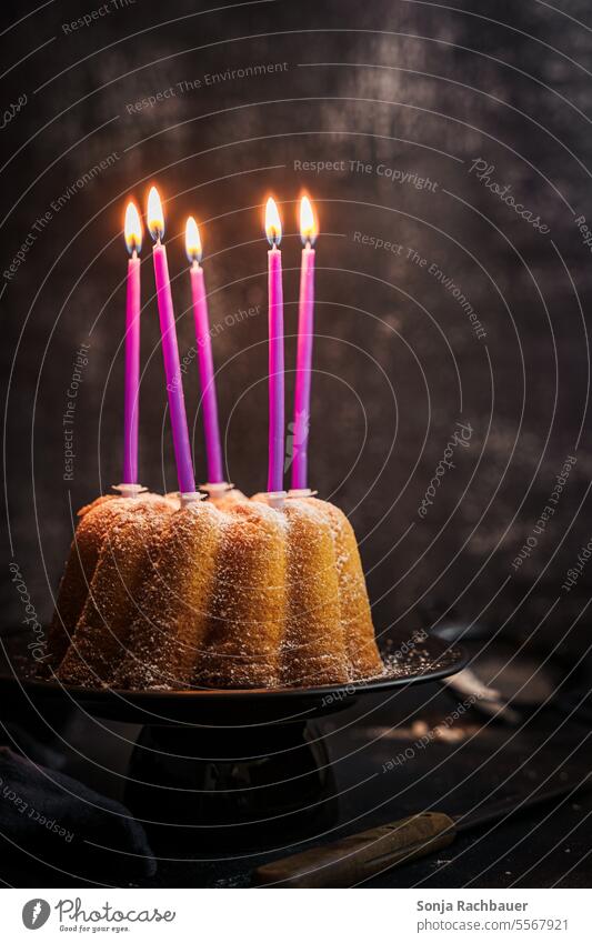 Ein Gugelhupf mit fünf brennenden Kerzen. Stillleben. Geburtstag mood Dessert Kuchen gebacken selbstgemacht Servierfertig süß lecker Lebensmittel Foodfotografie