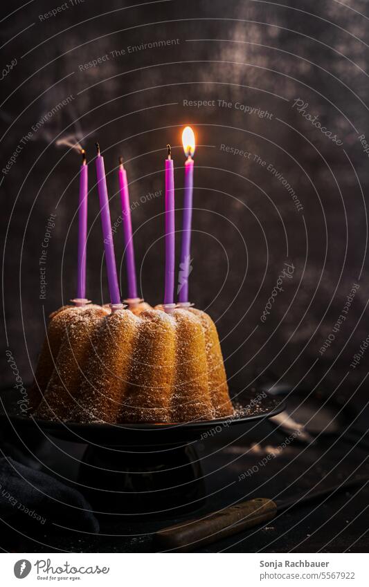 Ein Gugelhupf mit einer brennenden Kerze. Stillleben. Geburtstag Feste & Feiern Dessert gebacken selbstgemacht Kuchen süß lecker Geburtstagstorte Lebensmittel
