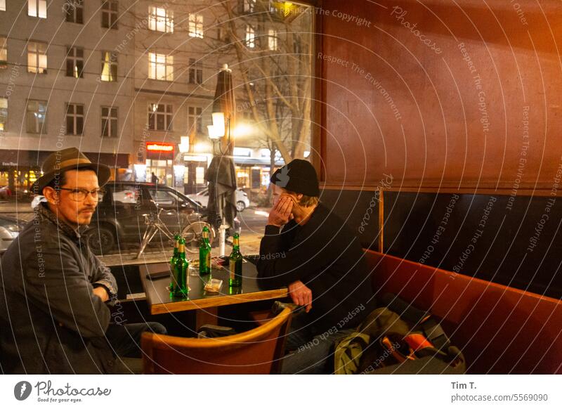 Zwei Männer sitzen am Fenster einer Bar in Berlin und trinken Bier Herbst Prenzlauer Berg Kneipe Café kastanienallee Abend Stadt Stadtzentrum Hauptstadt