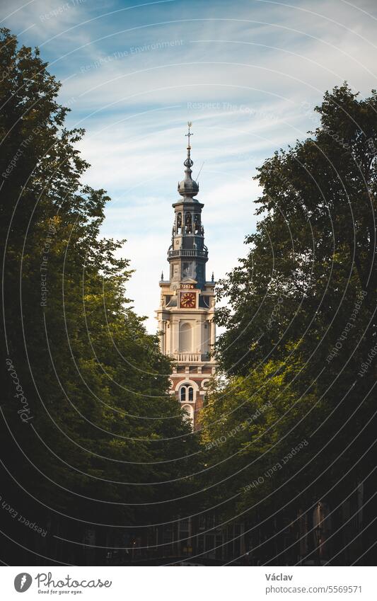 Baumallee, die an der Spitze einer Kirche endet, bei Tageslicht in Amsterdam, Niederlande. Westlich von Europa Kanal Reflexion & Spiegelung einzigartig