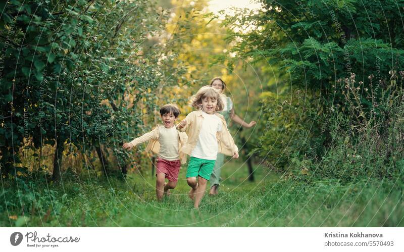 Spielende Kinder, die auf einem Grundstück im Landhaus rennen. Ökologisches Leben außerhalb der Stadt bezaubernd Hinterhof schön Junge heiter Kindheit Europa